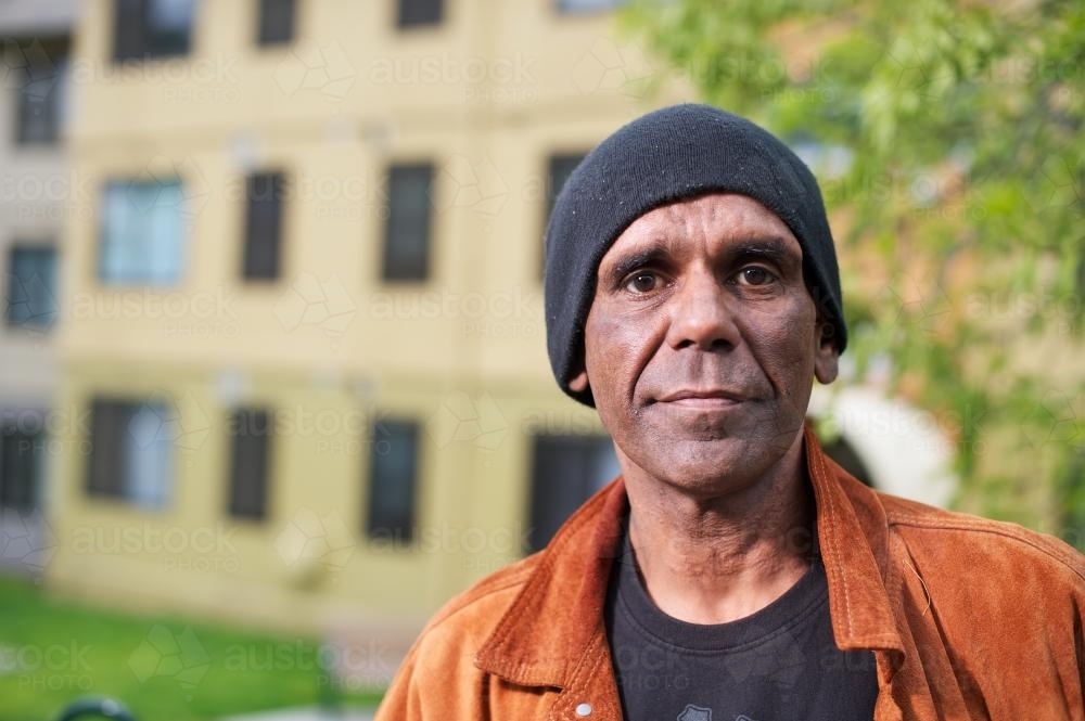 Aboriginal Man in his Forties with Building in Background - Australian Stock Image