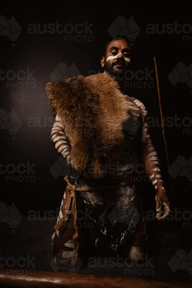 Aboriginal man painted up holding kangaroo skin - Australian Stock Image