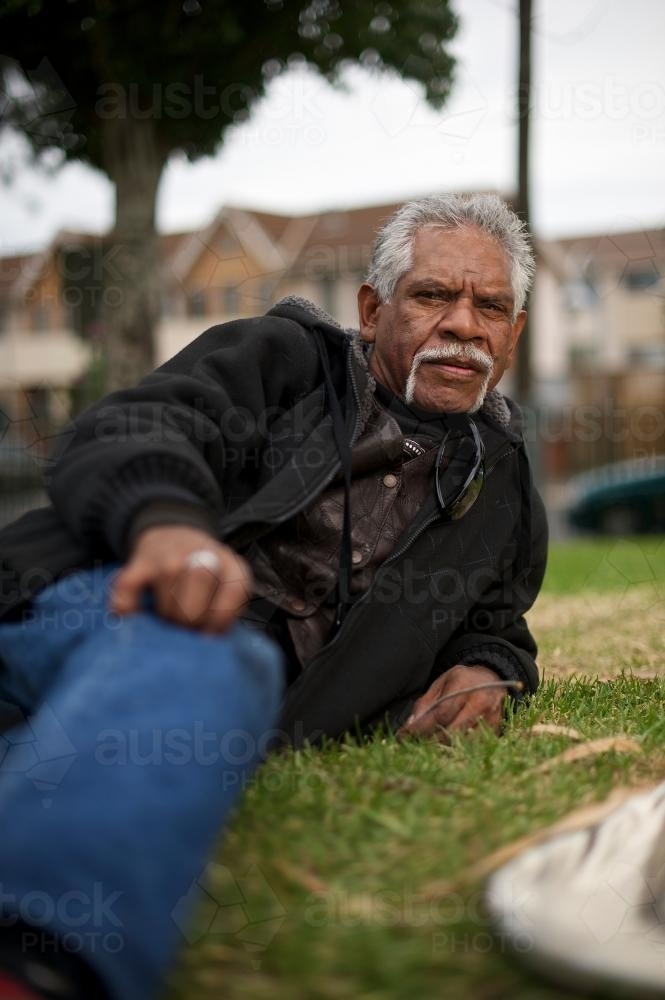 Aboriginal Man Reclining on the Grass - Australian Stock Image