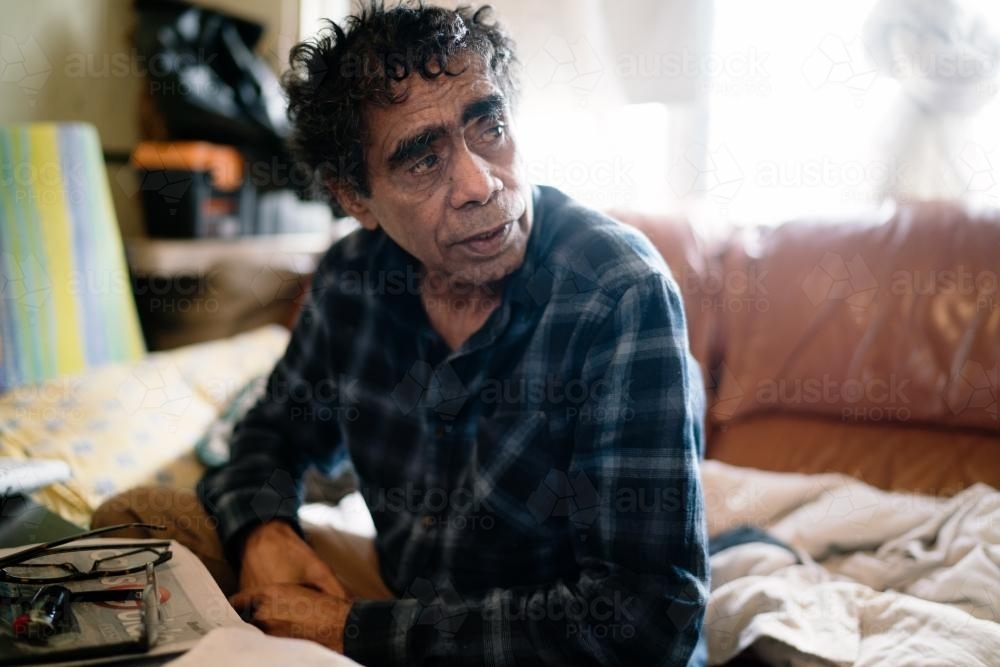 Aboriginal Man seated on a Couch - Australian Stock Image