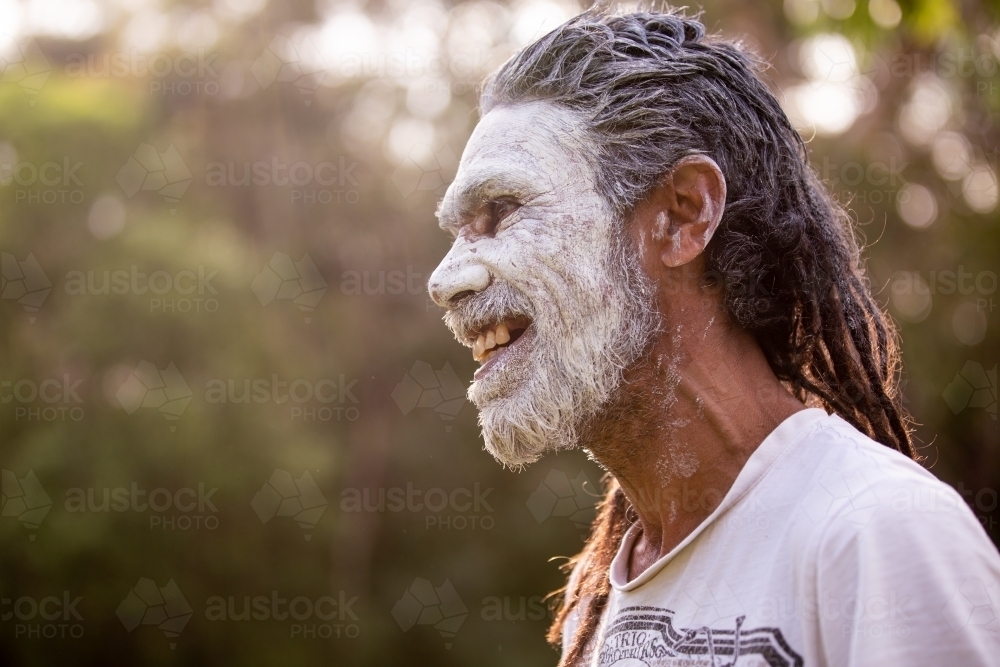 Aboriginal man wearing white face paint smiling - Australian Stock Image