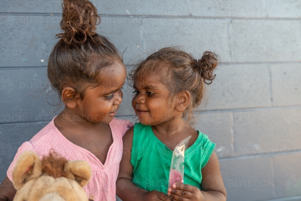 Aboriginal sisters looking at each other affectionately - Australian Stock Image