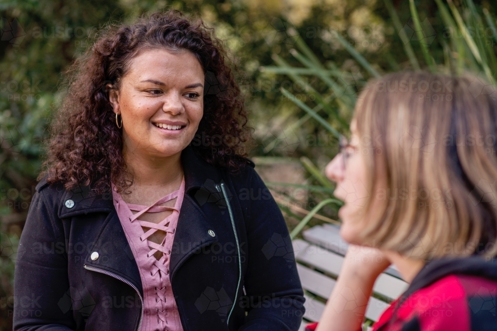 aboriginal student chatting with friend on campus - Australian Stock Image