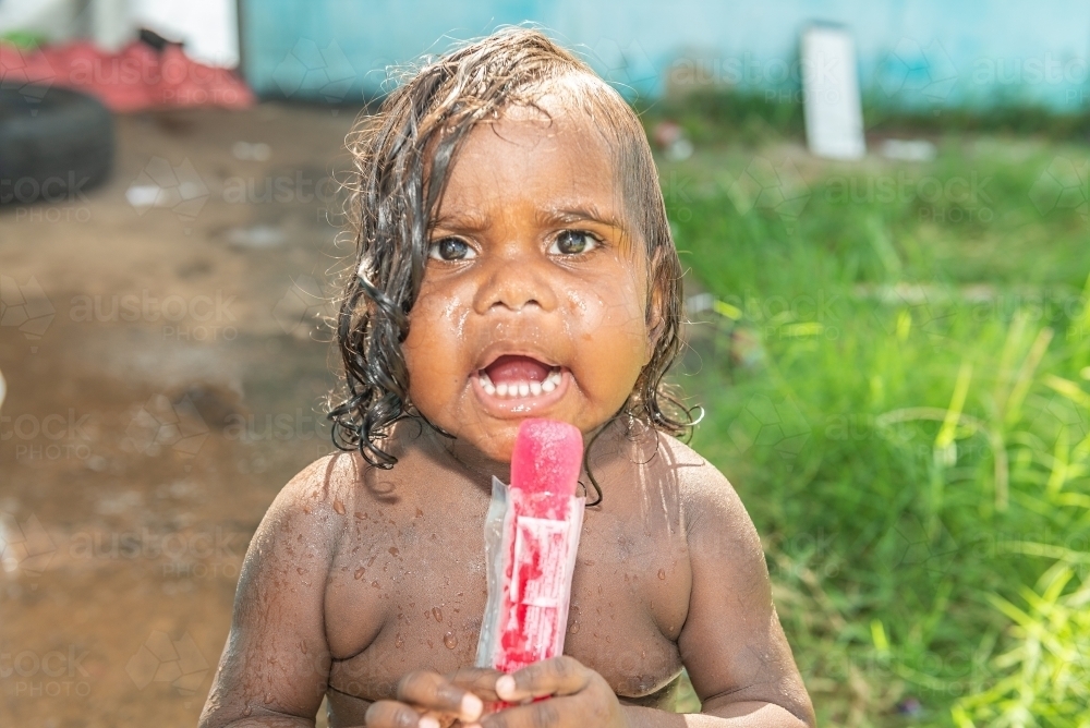 Aboriginal toddler eating icy pole - Australian Stock Image