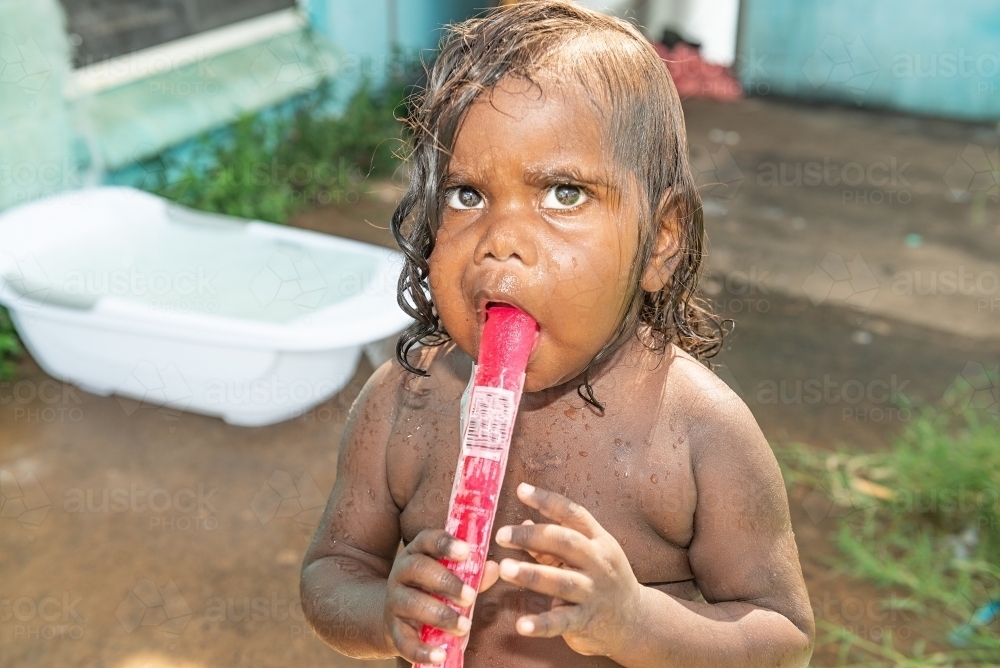 Aboriginal toddler eating icy pole - Australian Stock Image