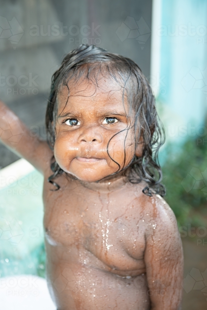 Aboriginal toddler playing in water - Australian Stock Image