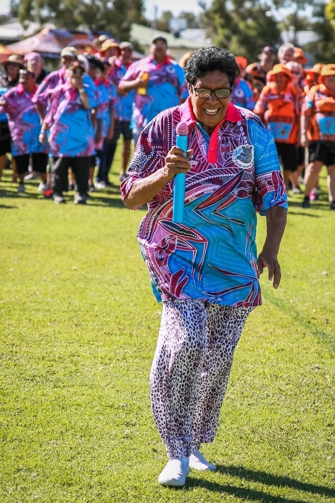 Aboriginal woman carrying baton in relay race - Australian Stock Image