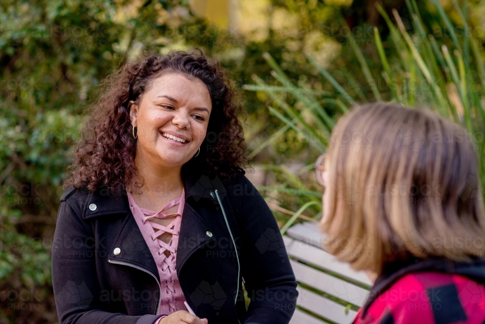 aboriginal woman chatting with friend - Australian Stock Image