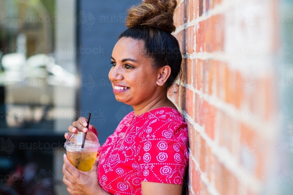 aboriginal woman drinking juice - Australian Stock Image