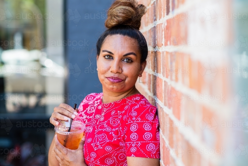 aboriginal woman drinking juice - Australian Stock Image