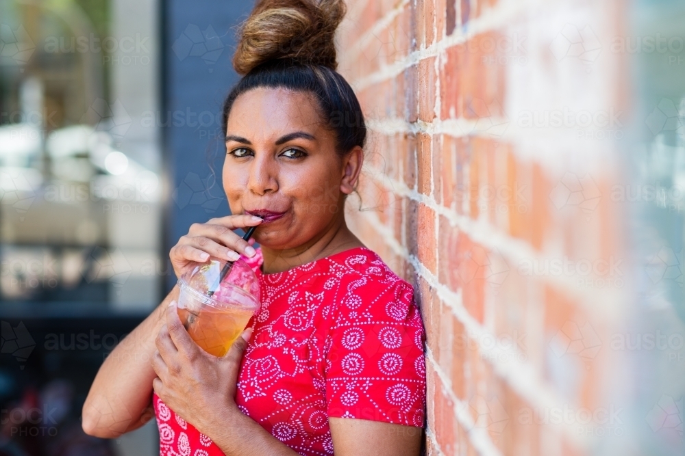 aboriginal woman drinking juice - Australian Stock Image