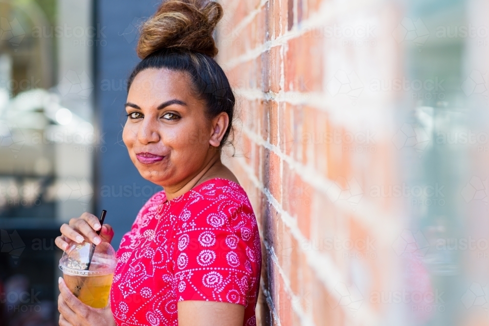 aboriginal woman drinking juice - Australian Stock Image