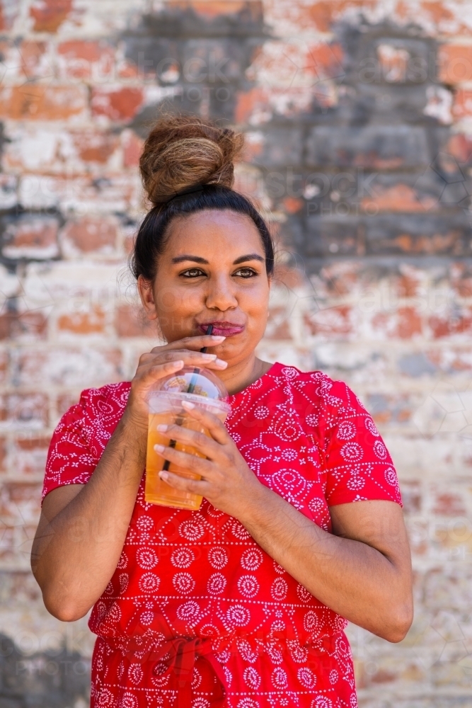 aboriginal woman drinking juice - Australian Stock Image
