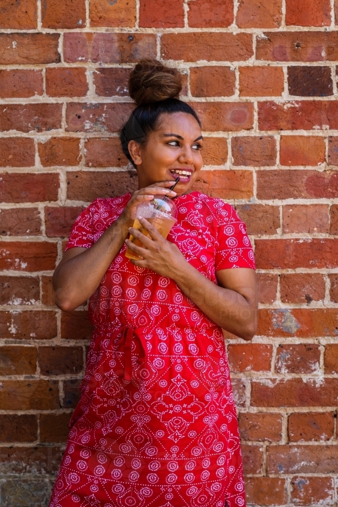 aboriginal woman drinking juice - Australian Stock Image