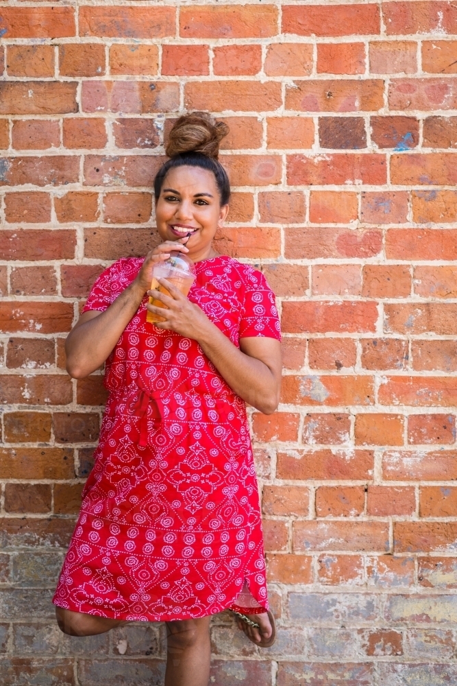 aboriginal woman drinking juice - Australian Stock Image
