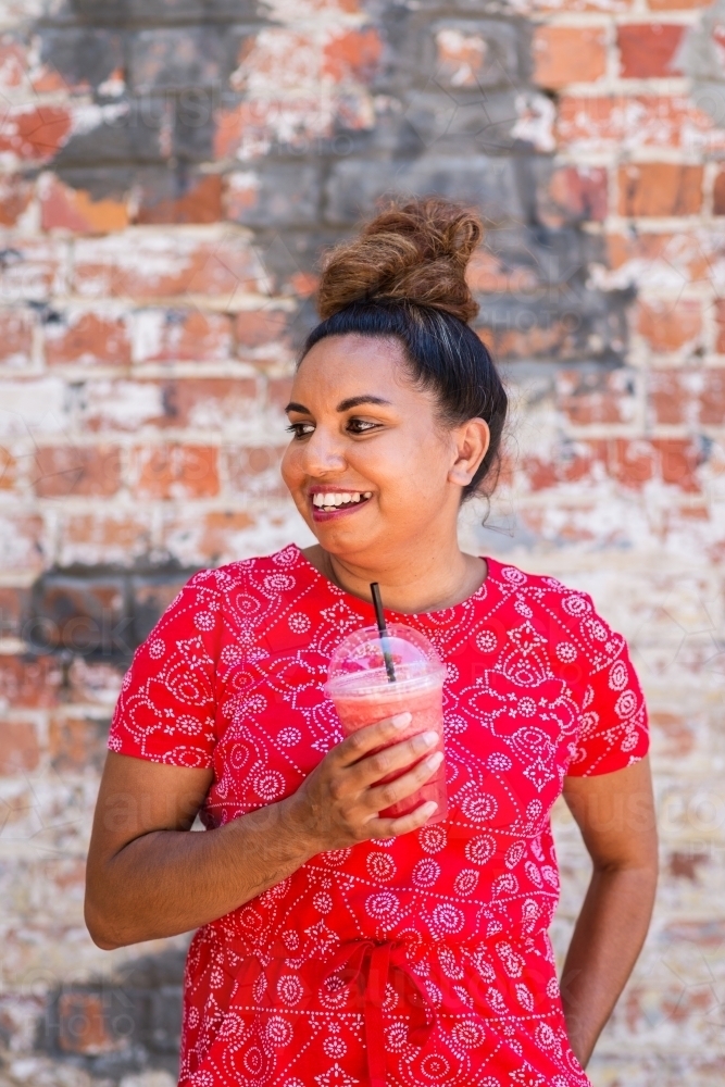 aboriginal woman drinking juice - Australian Stock Image