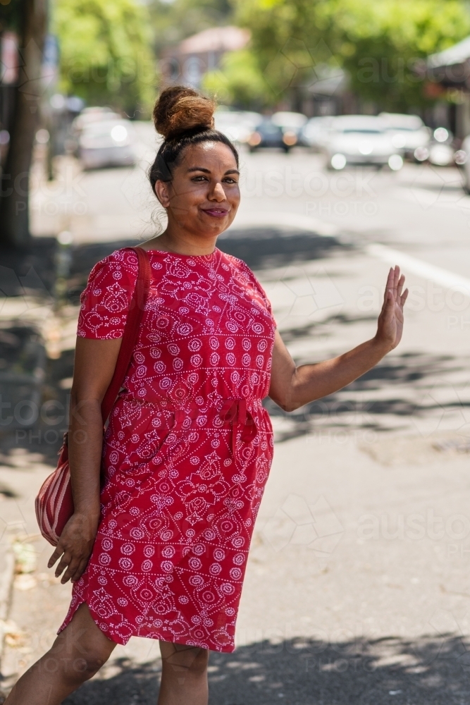 aboriginal woman hailing a taxi or bus - Australian Stock Image