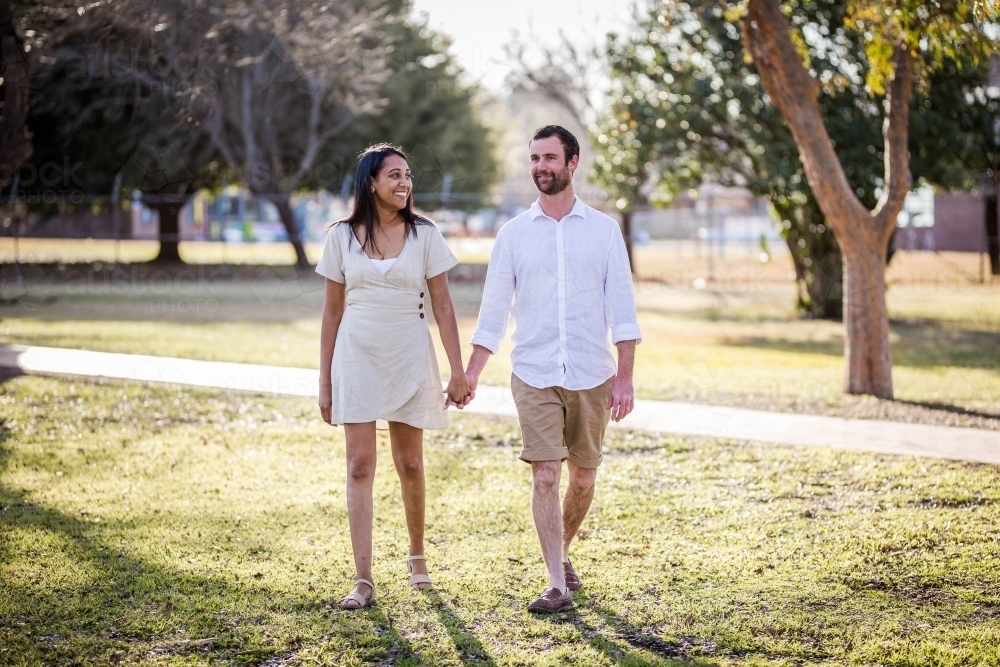 Aboriginal woman holding hands and laughing at Caucasian husband - Australian Stock Image