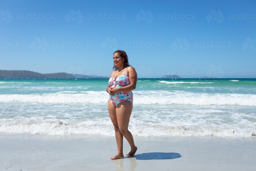 aboriginal woman in bathers on the beach - Australian Stock Image