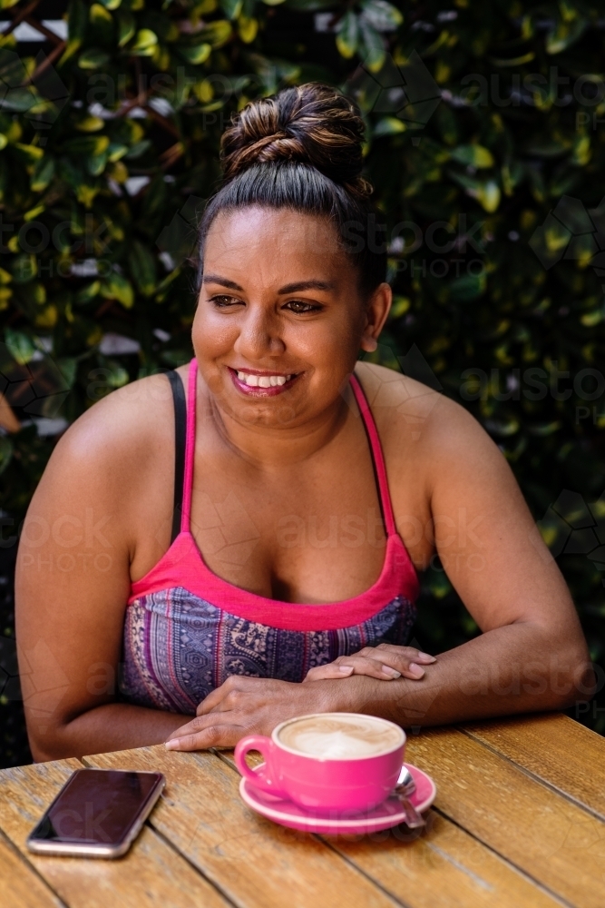 aboriginal woman in cafe with flat white coffee - Australian Stock Image