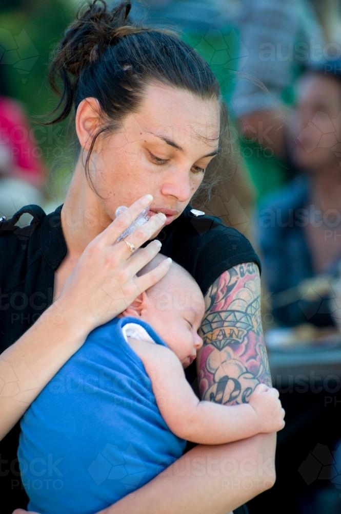 Aboriginal Woman Looking Down at Sleeping Baby - Australian Stock Image