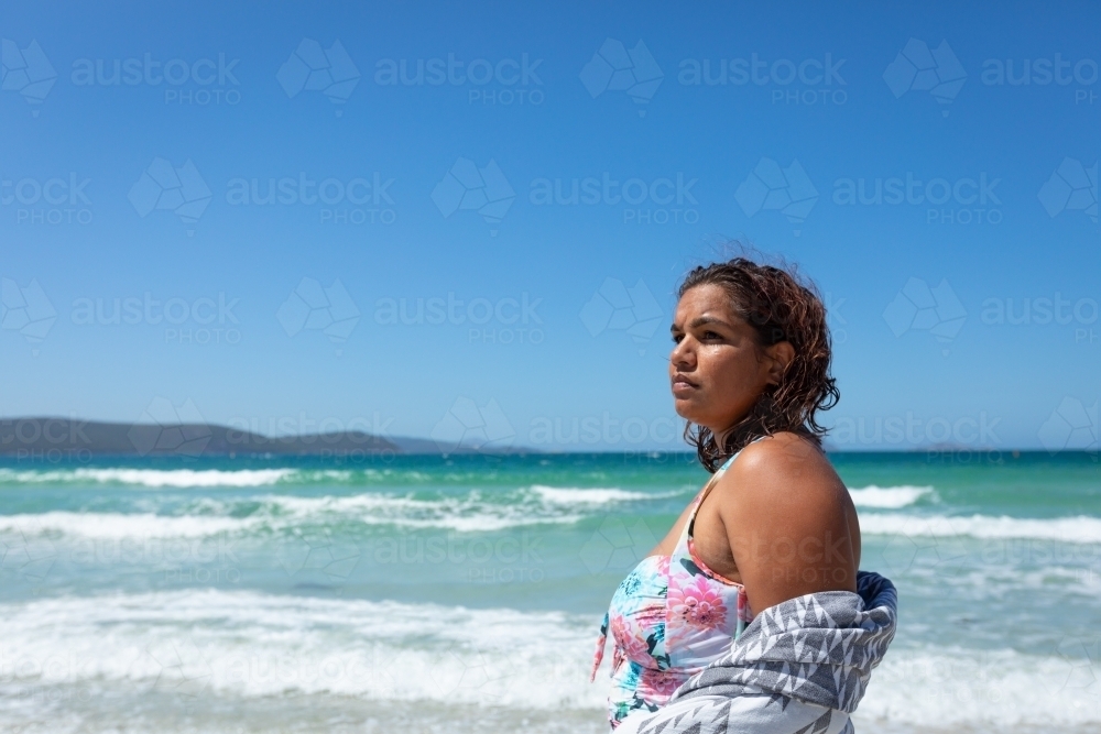 aboriginal woman on the beach with blue sky - Australian Stock Image