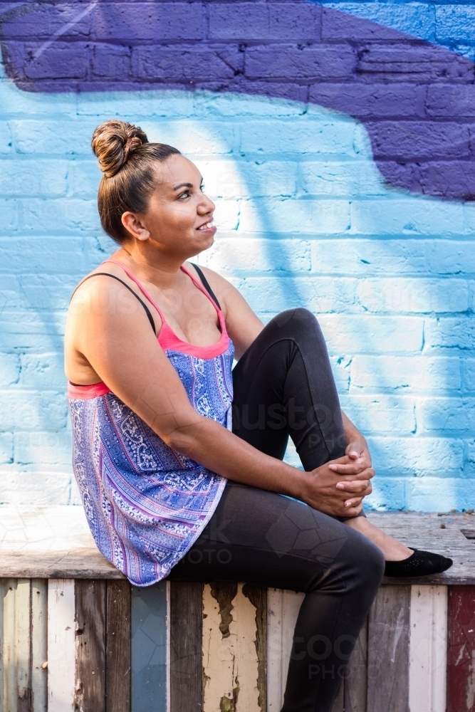 aboriginal woman sitting outdoors - Australian Stock Image