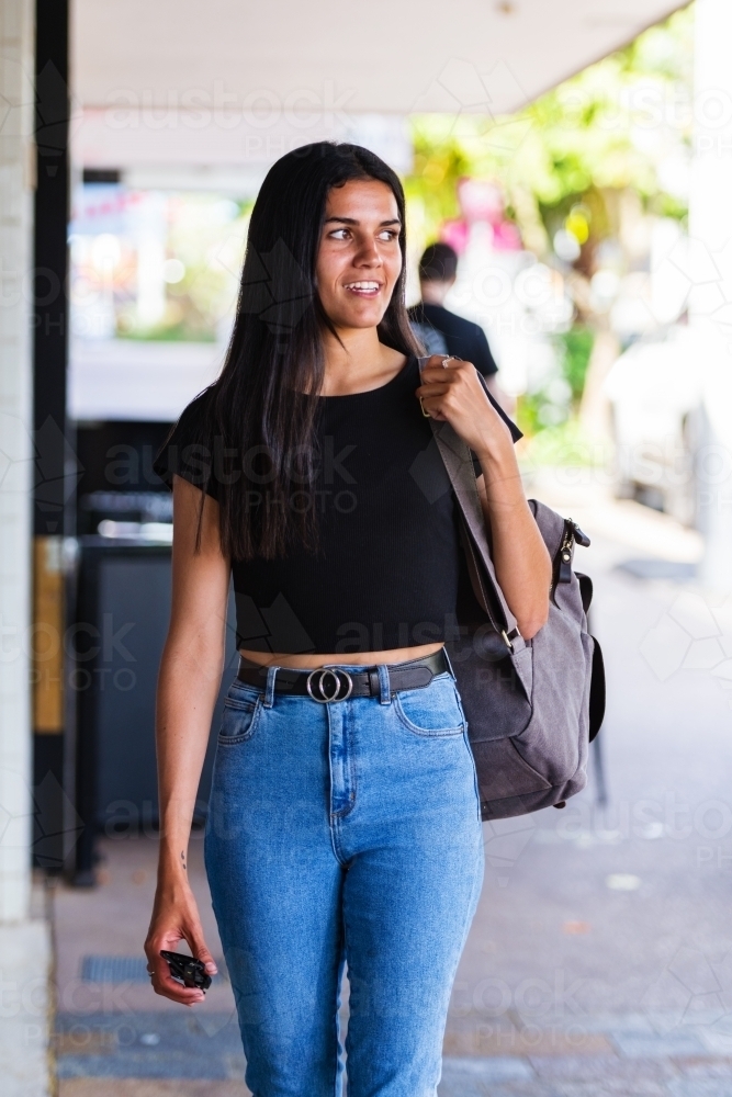 aboriginal woman walking in an urban setting - Australian Stock Image