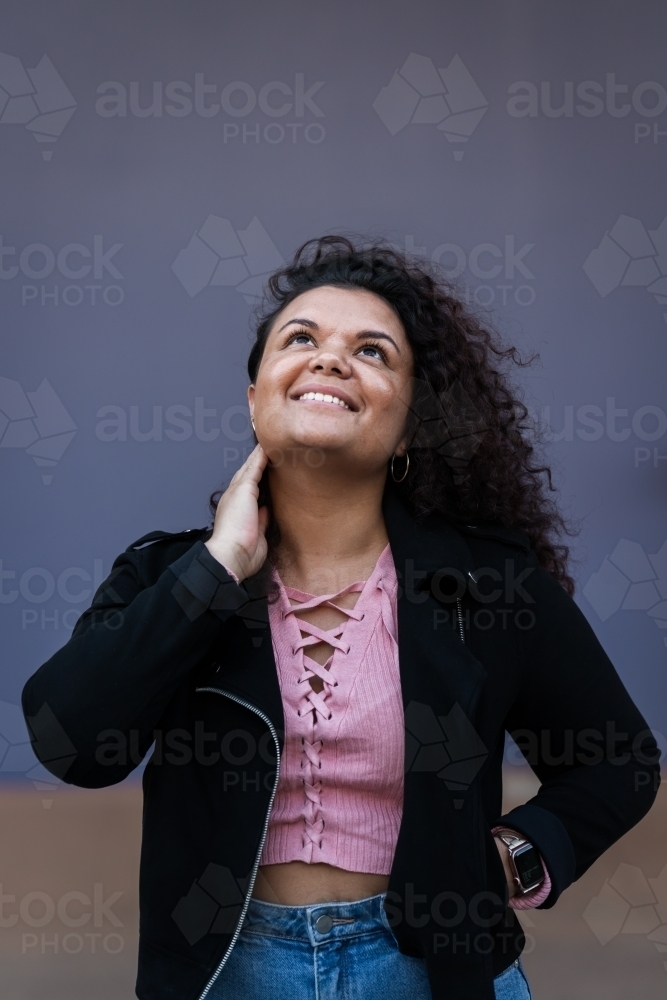 aboriginal woman with curly hair, looking up - Australian Stock Image