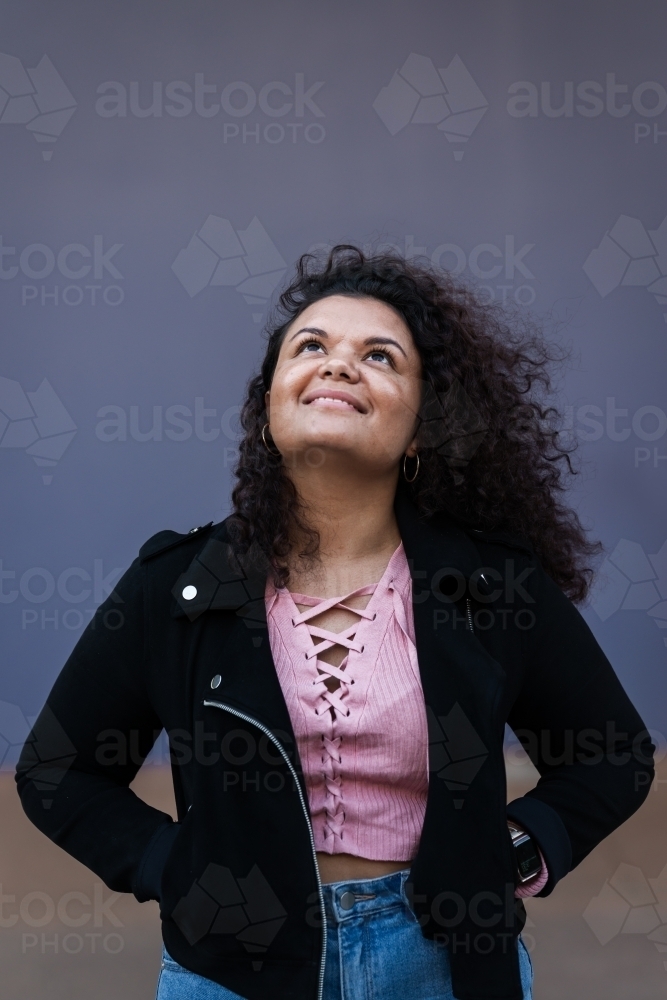 aboriginal woman with curly hair, looking up - Australian Stock Image