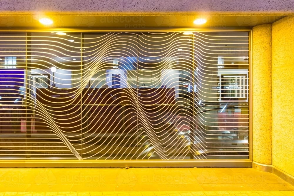 Image of Abstract metal designs in a window lit by artificial lighting ...