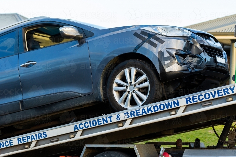 accident and breakdown recovery tow truck vehicle with car being pulled onto tray - Australian Stock Image