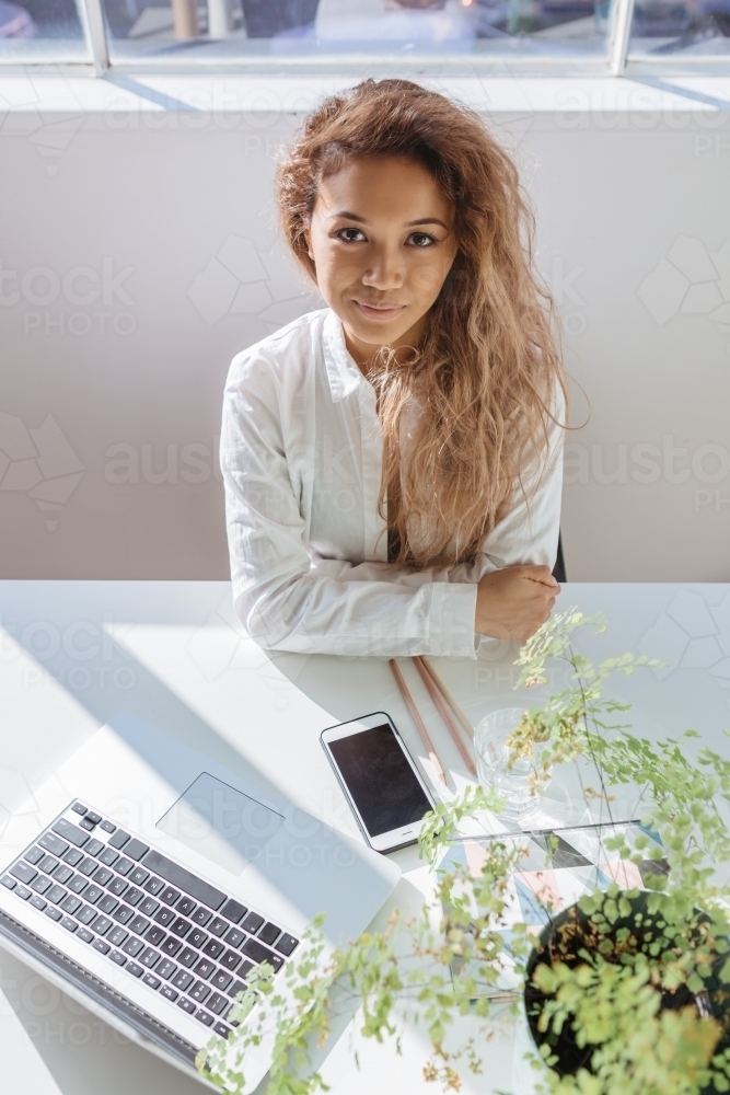 Accomplished looking professional young woman at her desk - Australian Stock Image