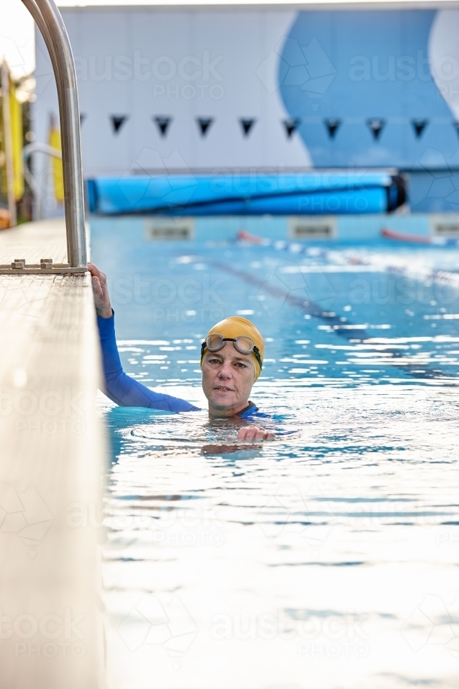 Active senior lady exercising in swimming pool - Australian Stock Image