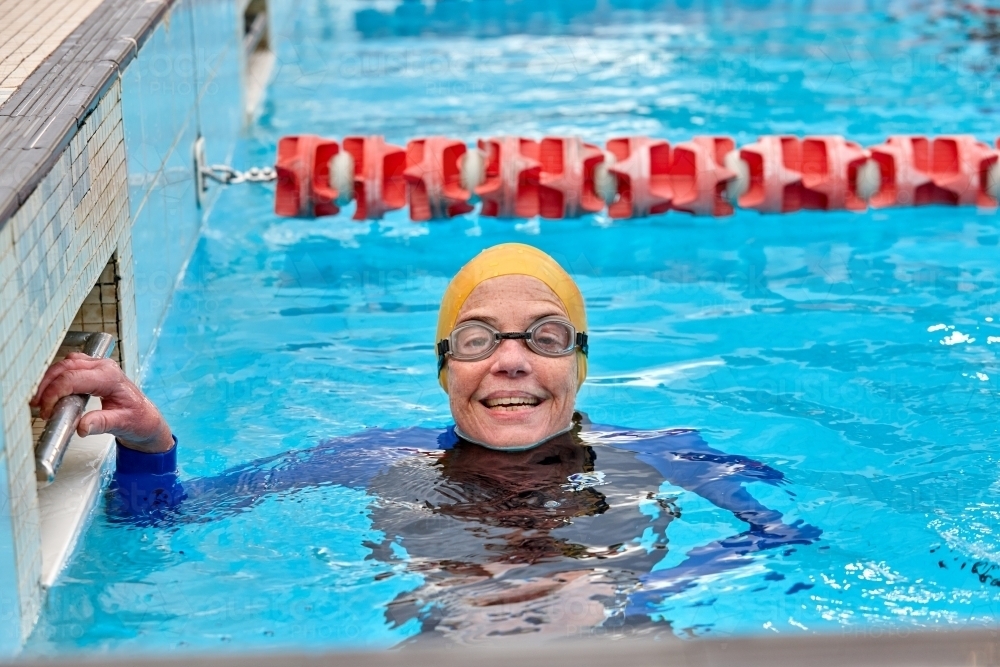 Active senior lady exercising in swimming pool - Australian Stock Image