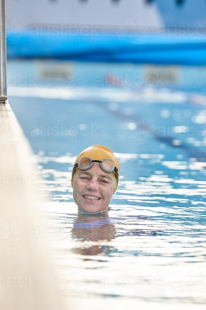 Active senior lady exercising in swimming pool - Australian Stock Image