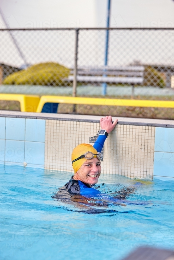 Active senior lady exercising in swimming pool - Australian Stock Image