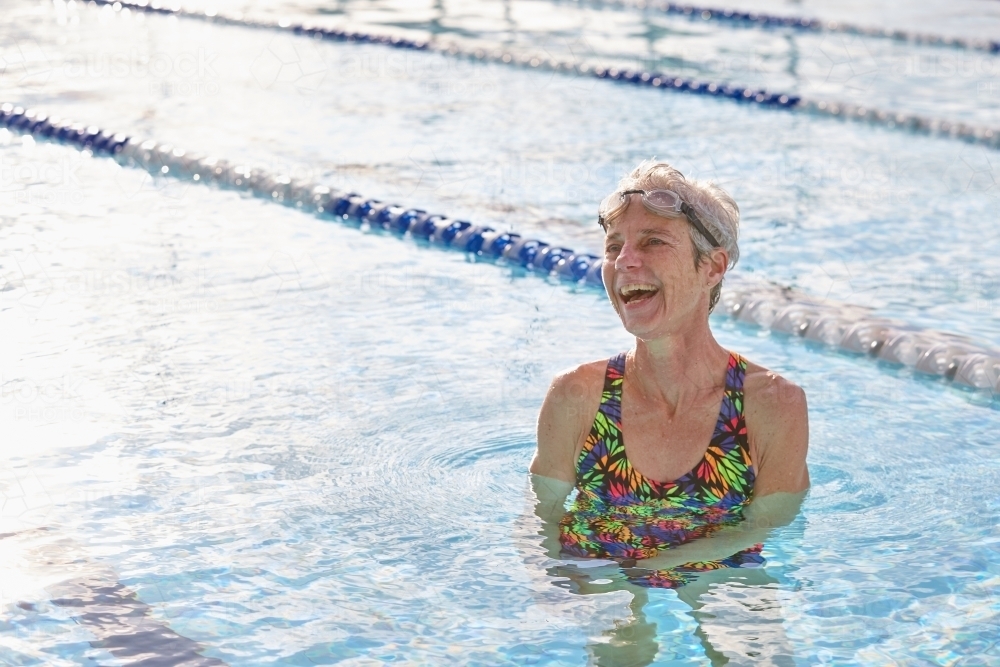 Active senior lady laughing in swimming pool - Australian Stock Image