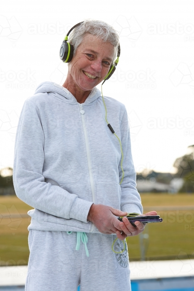 Active senior listening to music with headphones - Australian Stock Image