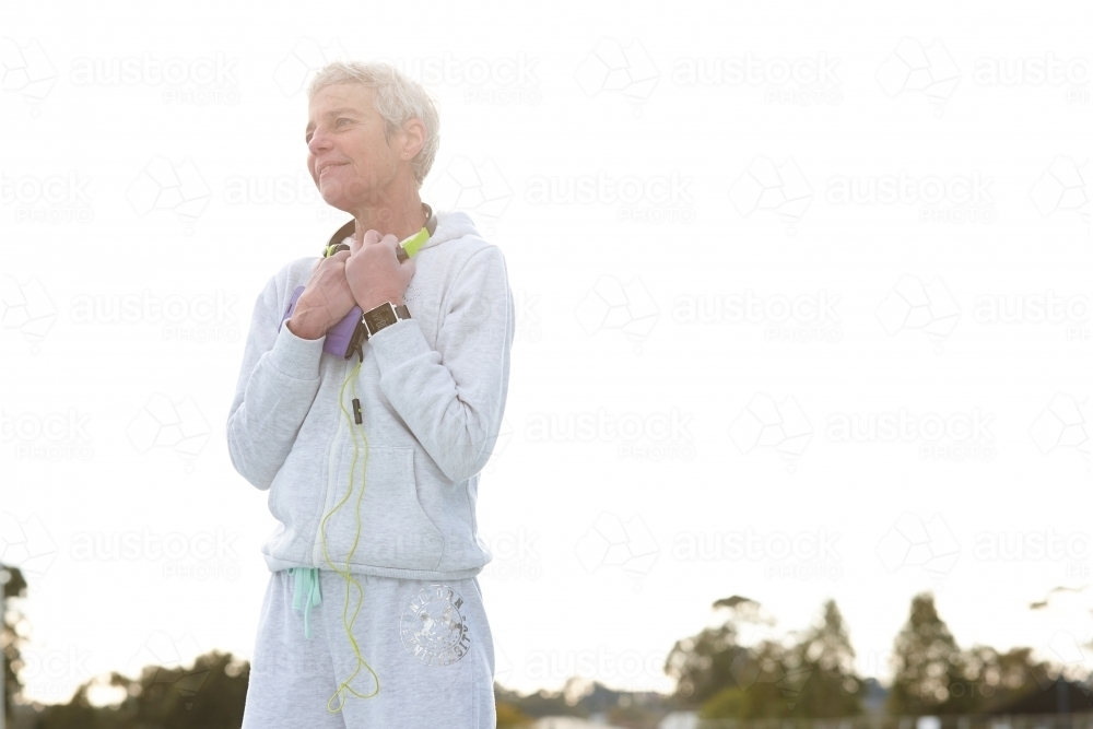 Active senior listening to music with headphones - Australian Stock Image