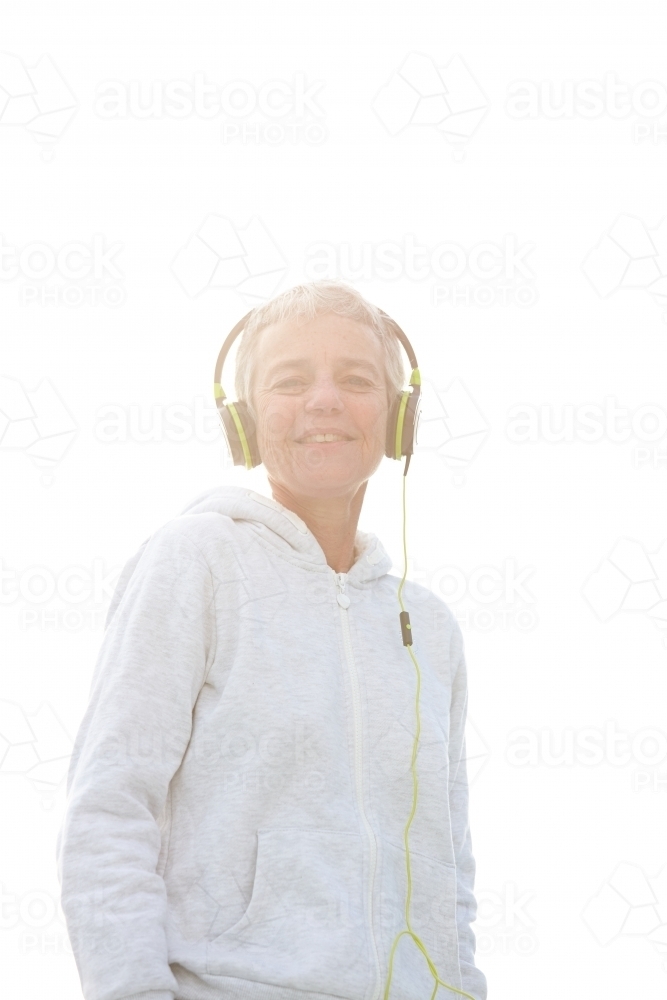 Active senior listening to music with headphones - Australian Stock Image