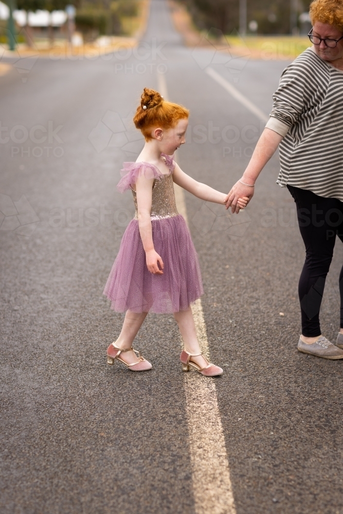 adult assisting child across road - Australian Stock Image