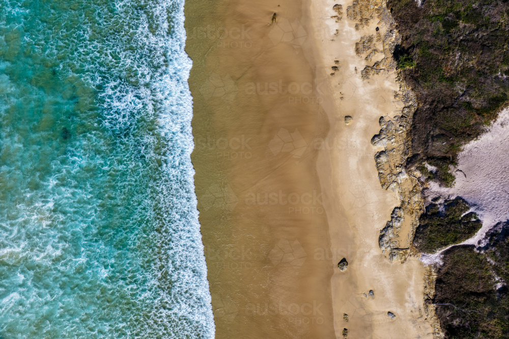 Aerial downward view of Sand Dune Beach at Brooms Head, showcasing the sandy shoreline and ocean - Australian Stock Image