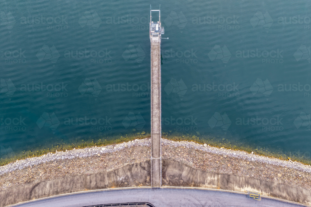 Aerial downward view of the Glenbawn Dam wall with the walkway leading out to the water intake - Australian Stock Image