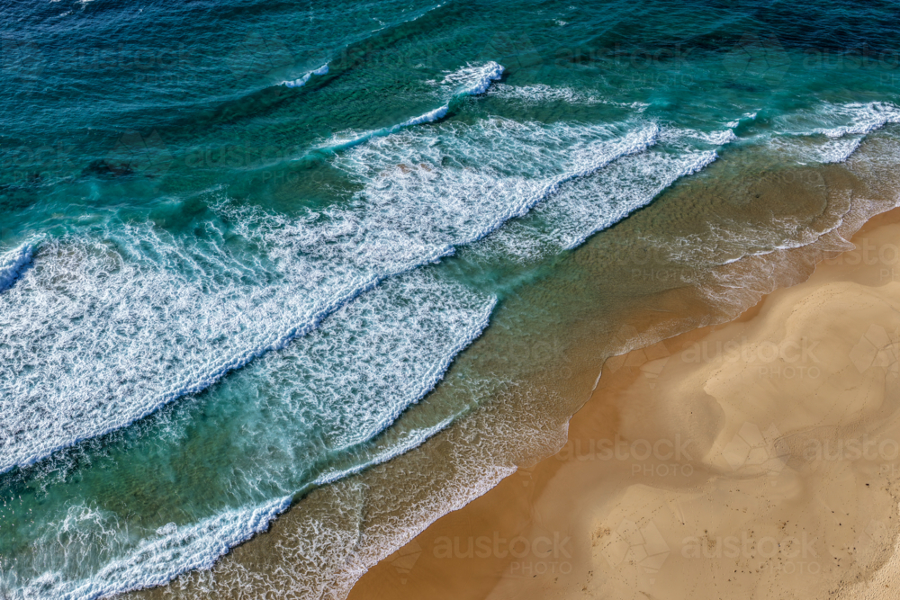 Aerial drone view of waves rolling onto the sandy shoreline at Nobbys Beach in Newcastle. - Australian Stock Image