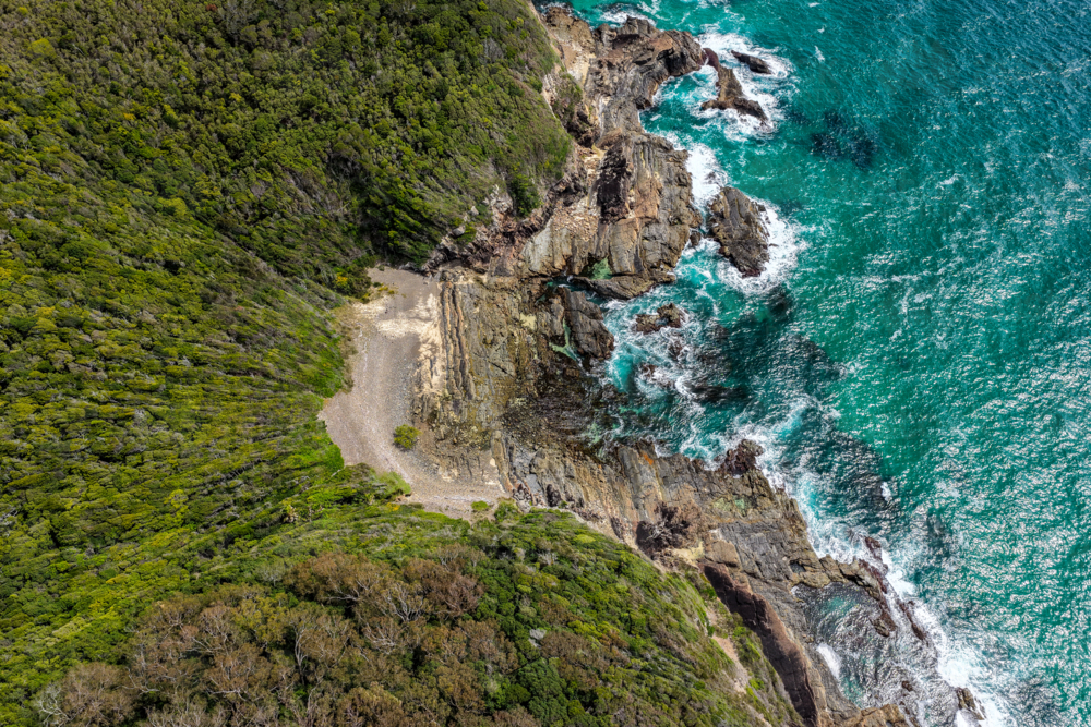 Aerial drone view over McBrides rockpool showing the natural rock formation along a rugged coastline - Australian Stock Image