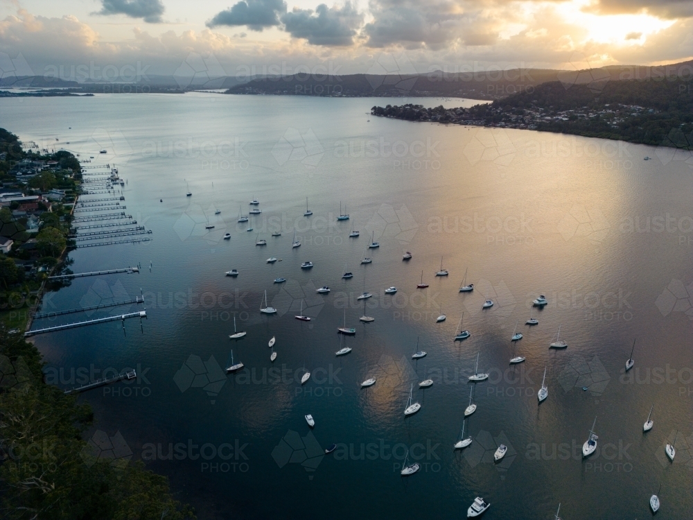 Aerial image looking south from Gosford at boats moored in Brisbane Water at dusk - Australian Stock Image
