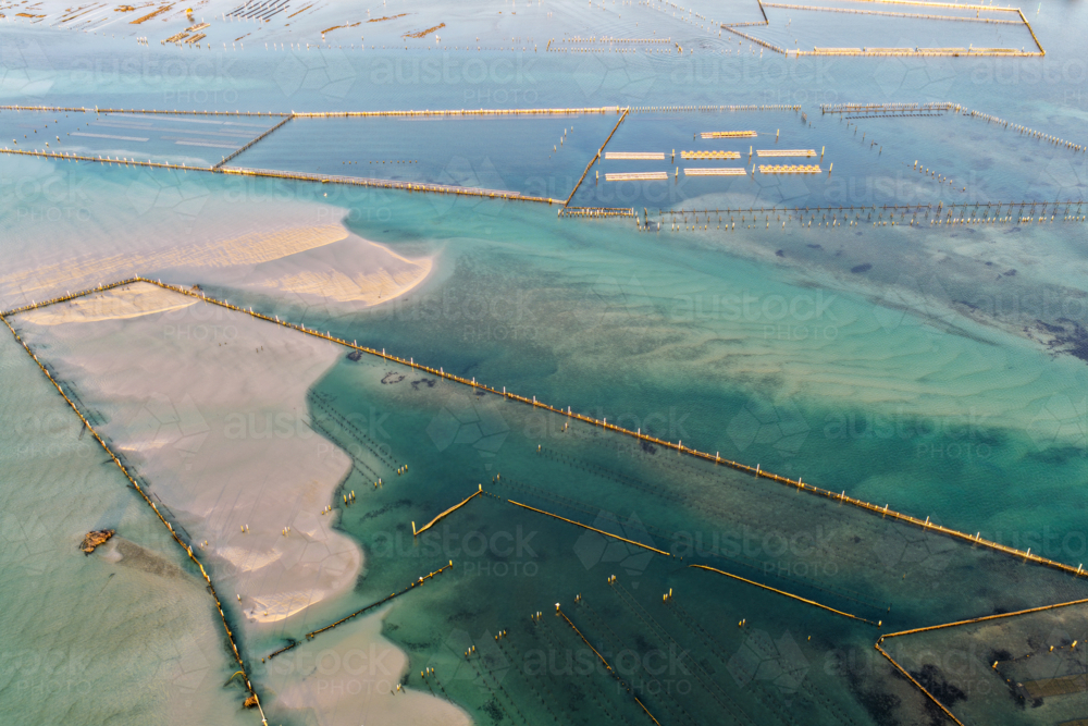 Aerial image showcasing the bright turquoise waters of Wallis Lake at low tide with patterns in sand - Australian Stock Image