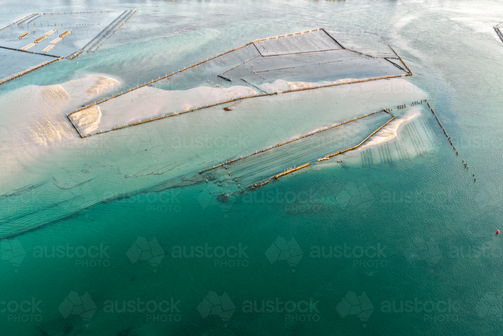 Aerial image showcasing the bright turquoise waters of Wallis Lake at low tide with patterns in sand - Australian Stock Image