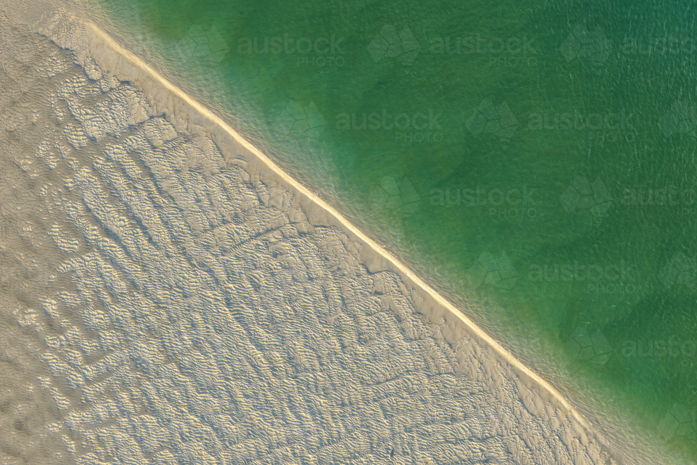 Aerial image showcasing the bright turquoise waters of Wallis Lake at low tide with patterns in sand - Australian Stock Image